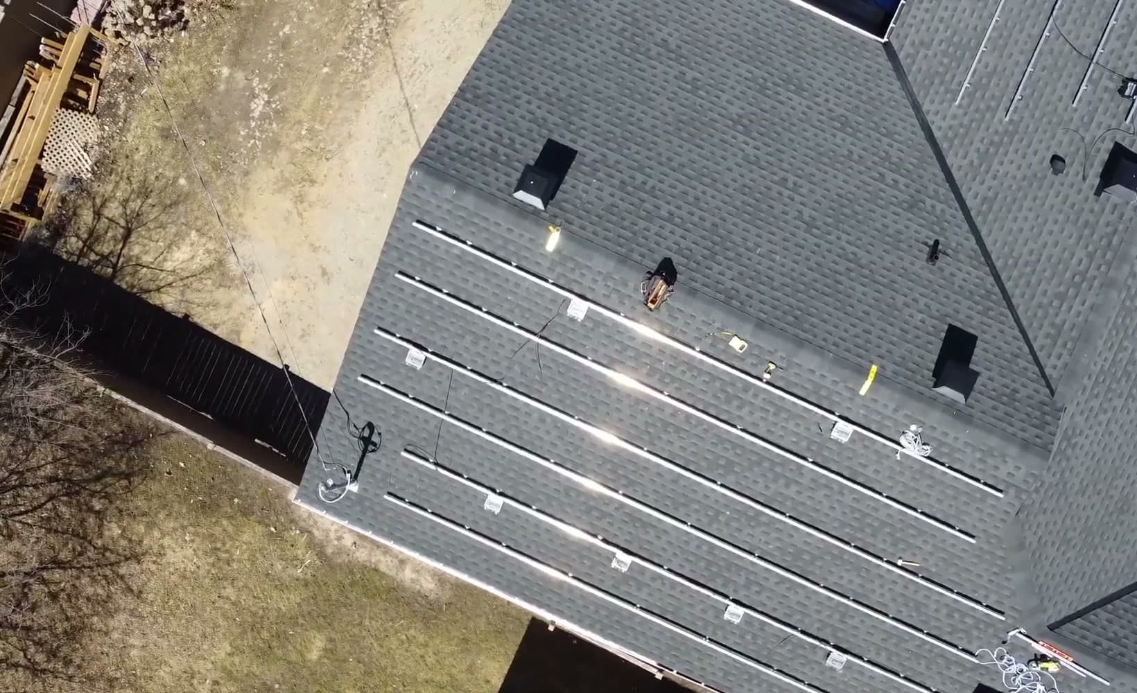 Drone view of racking rails fixed to a shingled roof, ready for the solar panels